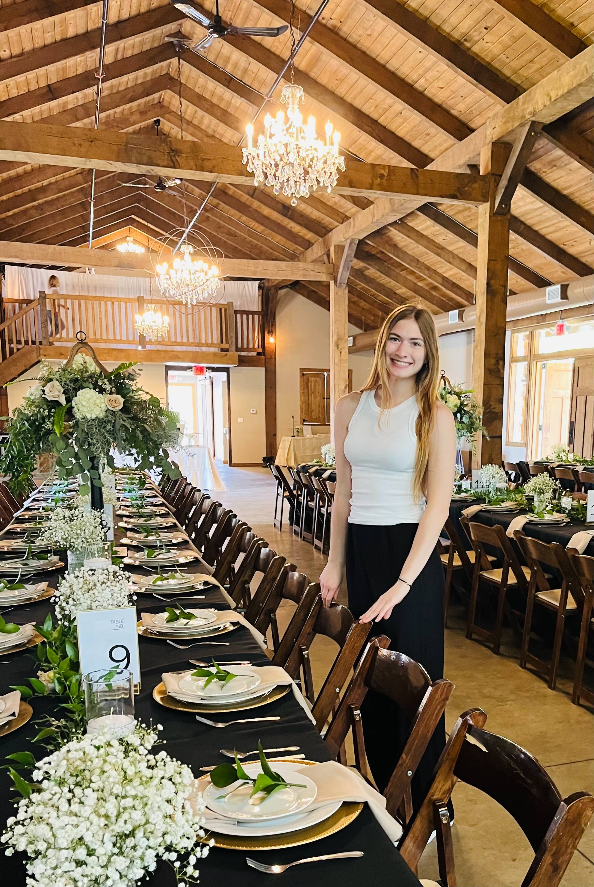 Young woman standing next to a decorated table in a wooden building